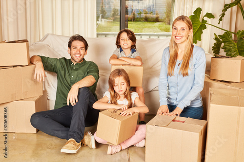 Family with two children between moving boxes