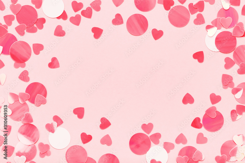 Festive frame of red hearts confetti on pink pastel background love Valentine's Day.