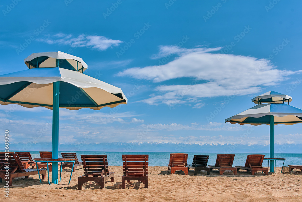 Sunbeds on the beach. Sun loungers with seats on the beach.