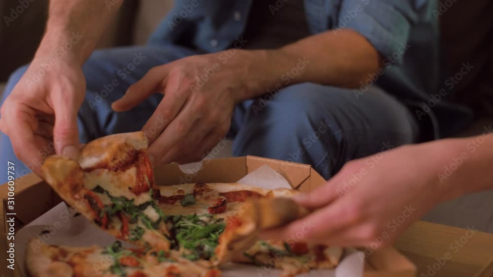 leisure, people and fast food concept - happy couple opening and eating takeaway pizza at home in evening leisure, people and fast food concept - happy couple opening and eating takeaway pizza at home in evening