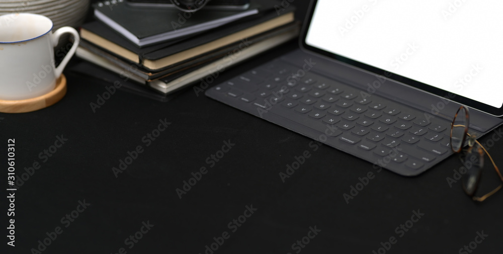 Cropped shot of dark trendy workplace with tablet and office supplies with copy space Cropped shot of dark trendy workplace with tablet and office supplies with copy space