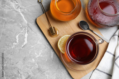 Flat lay composition of tea with honey on light grey marble table. Space for text