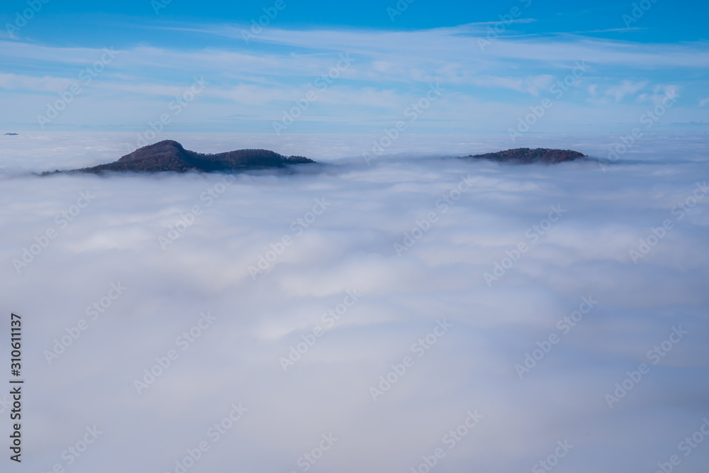 Germany, Endless aerial view above fog clouds in valley of swabian jura nature landscape on a sunny day with blue sky near stuttgart, seen from hohenneuffen