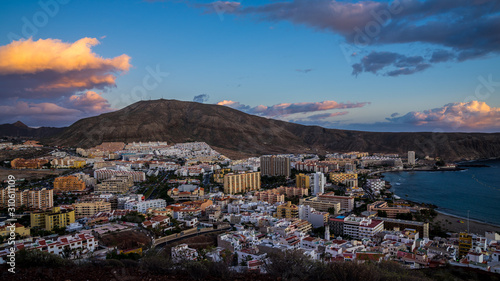 Spain, Tenerife, Tourist resort city in south, houses of los christianos with colorful sunset sky clouds in magical twilight atmosphere from above © Simon