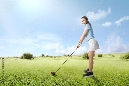 Asian woman with a golf club ready to play golf