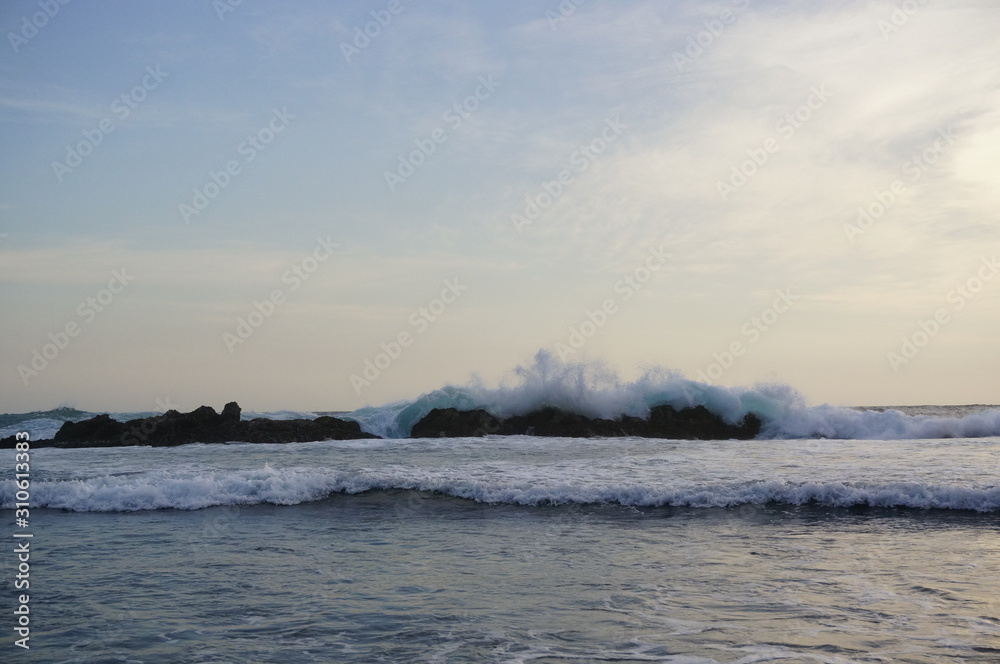 the atmosphere of the beach or the coast before the afternoon with calm waves and sunny weather set against the background of the high seas and mountains or plateaus the atmosphere of the beach or the coast before the afternoon with calm waves and sunny weather set against the background of the high seas and mountains or plateaus