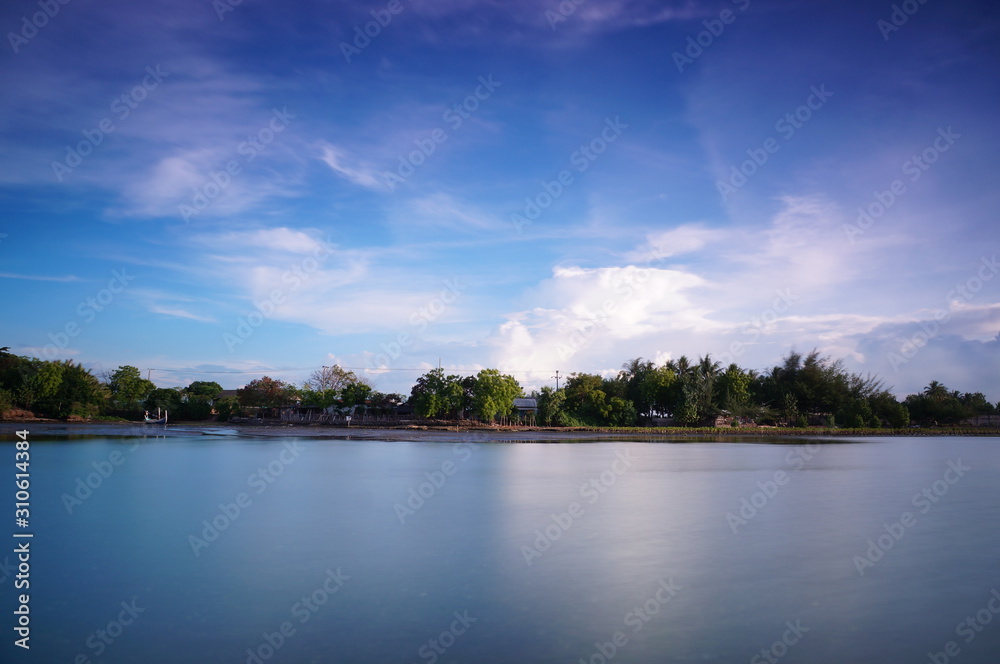 the atmosphere of the beach or the coast before the afternoon with calm waves and sunny weather set against the background of the high seas and mountains or plateaus the atmosphere of the beach or the coast before the afternoon with calm waves and sunny weather set against the background of the high seas and mountains or plateaus