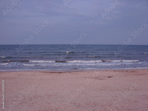 Panorama of the stormy water surface of the Sea of ​​Azov, which connects on a boundless horizon with a cloudy evening sky. photo