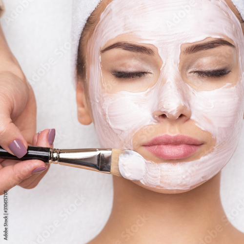 Canvas Print Woman receiving facial mask at beauty salon