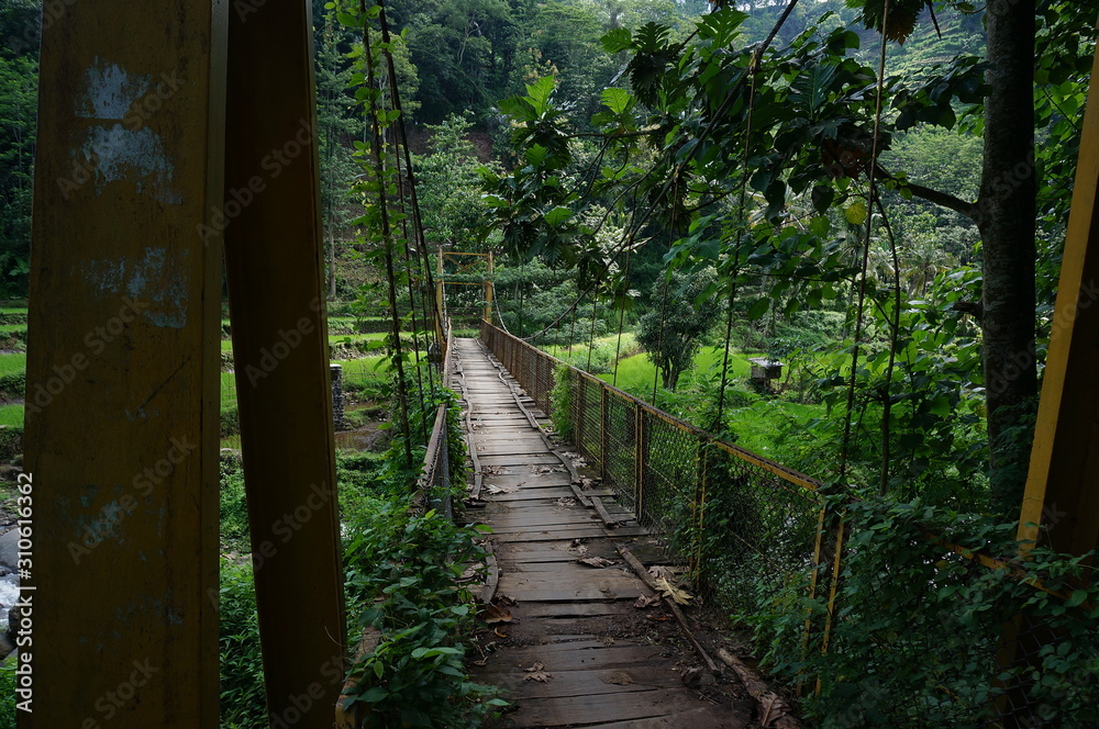 Obraz premium a suspension bridge still made of wood and an iron stand was used to cross the river connecting the two villages