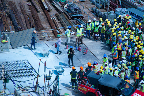 Construction workers wearing helmets at a construction site learning fire fighting skills