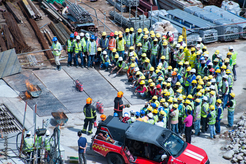 Construction workers wearing helmets at a construction site learning fire fighting skills