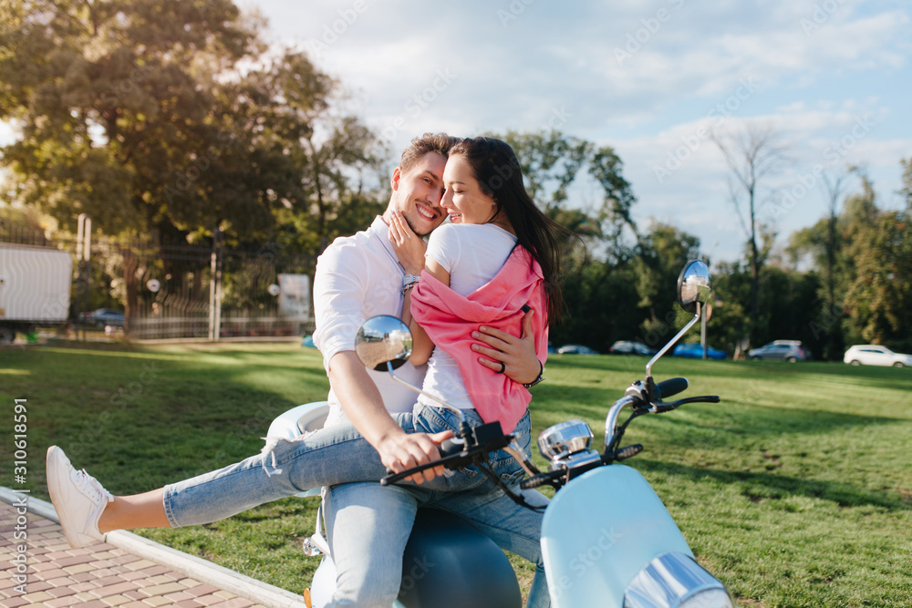 custom made wallpaper toronto digitalBlissful girl with black straight hair stroking boyfriend's face while sitting on scooter. Outdoor portrait of young couple resting together in park after riding around town.