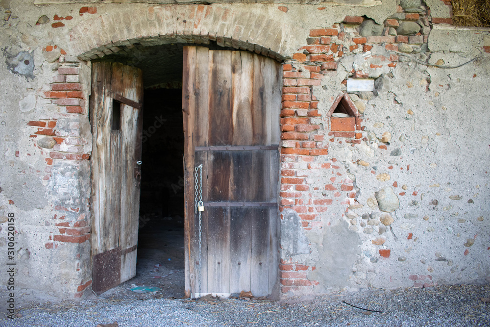 Entrance to abandoned building with brick walls and wooden door