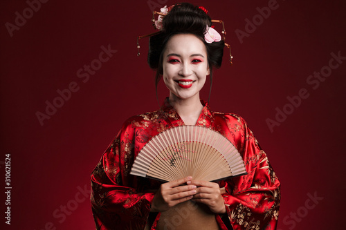 Foto Image of young geisha woman in japanese kimono holding wooden hand fan