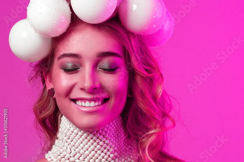 Beauty portrait of a girl with Christmas balls wreath on her head. The mood of the new year. Copy space.