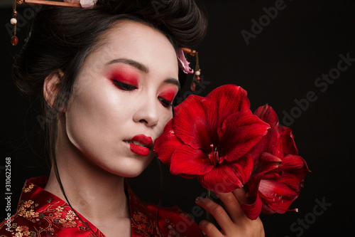 Foto Image of beautiful geisha woman in japanese kimono holding flowers