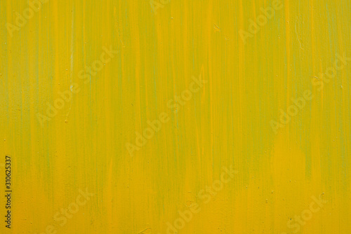 Yellow paint strokes on a metal sheet. Copy space