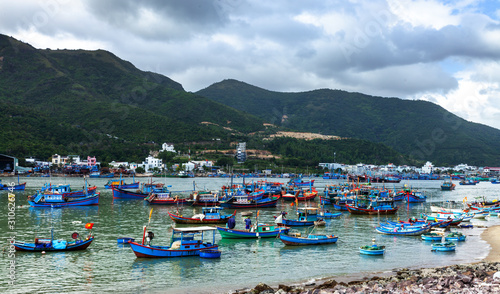 Many traditional vietnamese fishing boats in Nha Trang port in the cloudy day. photo