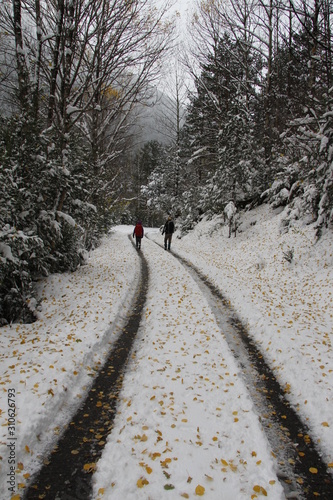 dos personas caminando por carretera nevada