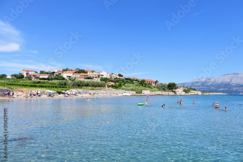 Locals and tourists enjoying a beautiful summer day along the sandy beaches of Lumbarda Beach on Korcula Island, Croatia