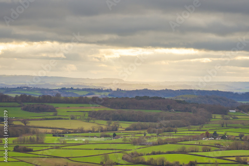 Wide angle view of dramatic english countryside landscape with hills and sunlight on the horizon