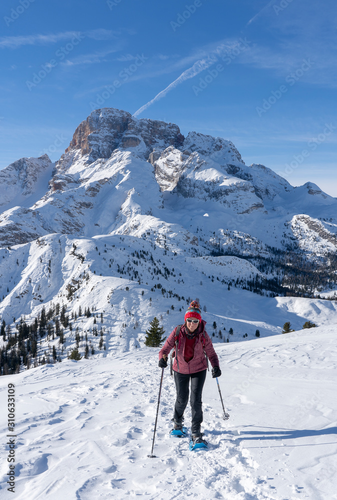 active senior woman snowshoeing from Prato Piazzo up to the Monte Specie in the three oeaks Dolomites area near village of Innichen, South Tyrol, Italy active senior woman snowshoeing from Prato Piazzo up to the Monte Specie in the three oeaks Dolomites area near village of Innichen, South Tyrol, Italy