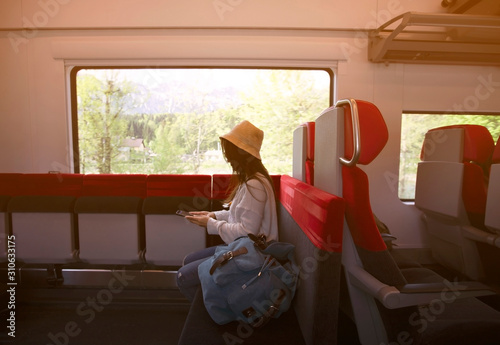 Young Asian woman tourist which  traveling by train and working on smartphone travel concept.