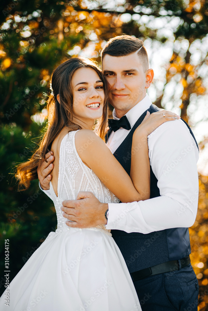 Portrait of beautiful couple in hugs on background of autumn trees