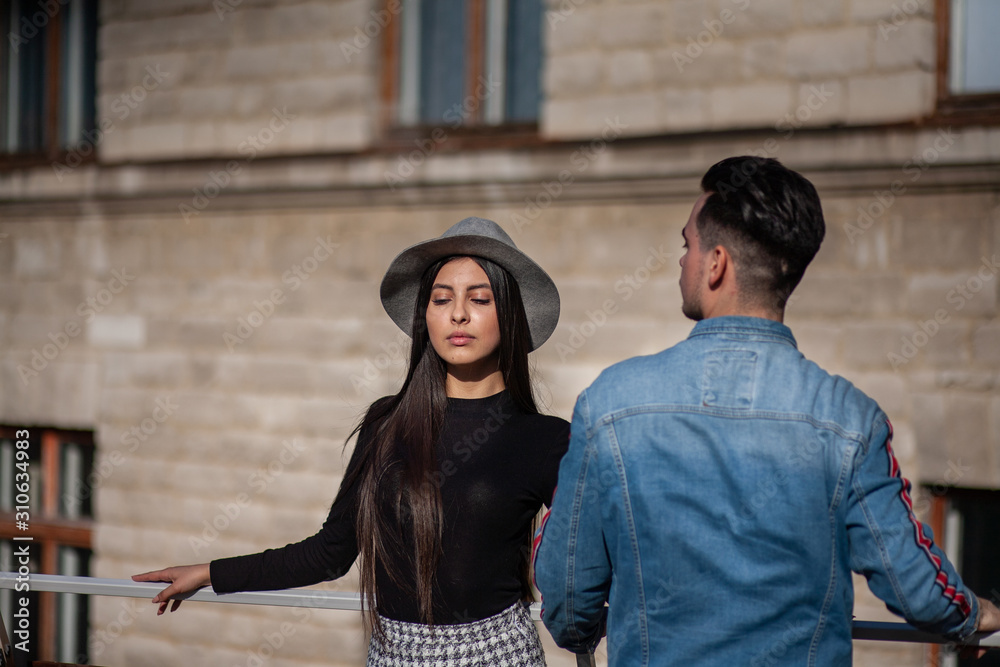 Obraz premium Stylish guy and girl posing in front of the camera on the street.