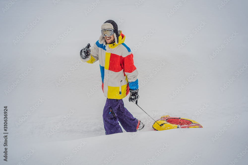 man snow tubing from hill. winter activity concept