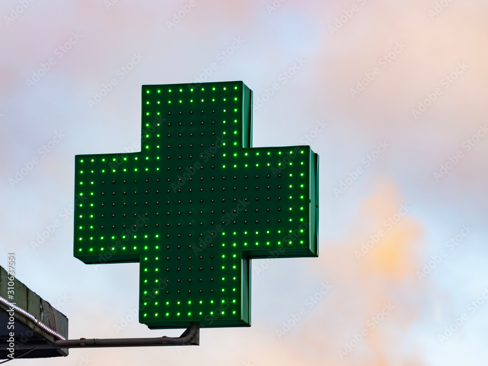 Green medical cross sign in winter day Green medical cross sign in winter day