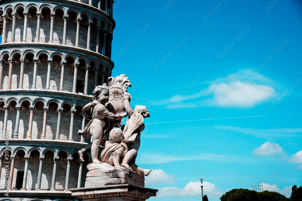 Monument on the background of the famous sloping tower with columns in Pisa, Italy. fascinating exotic amazing places.