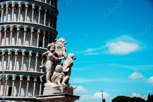 Obraz na płótnie Monument on the background of the famous sloping tower with columns in Pisa, Italy. fascinating exotic amazing places. w salonie