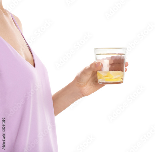 Young woman with glass of lemon water on white background, closeup