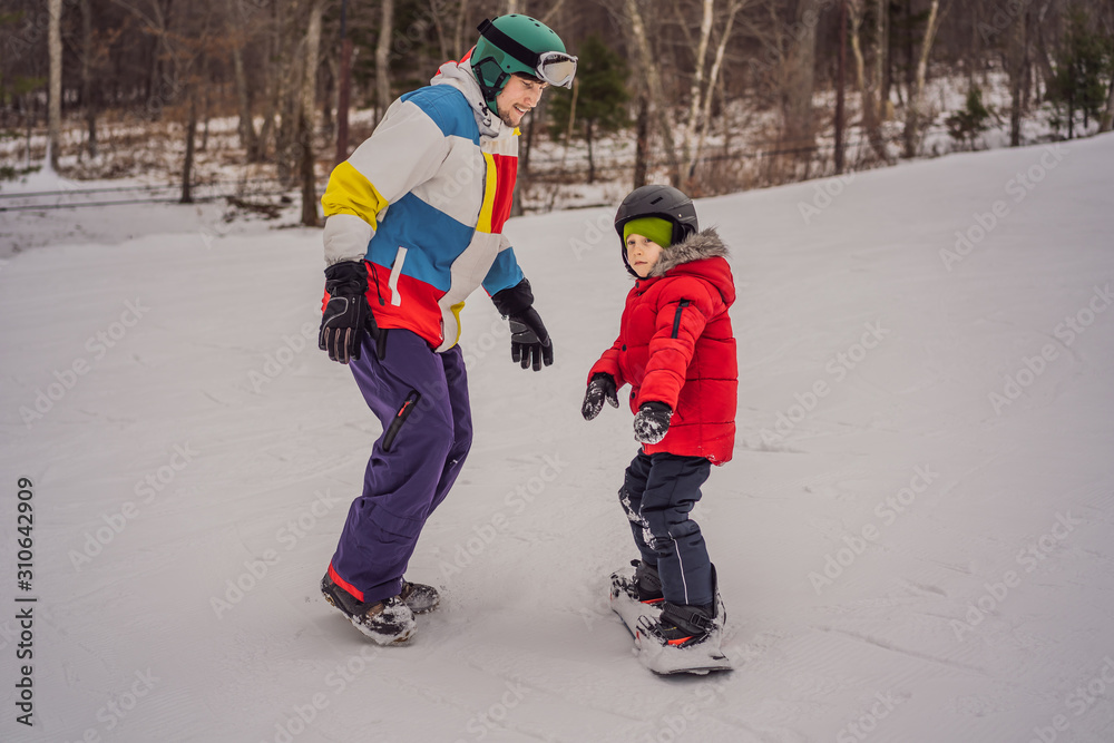 Snowboard instructor teaches a boy to snowboarding. Activities for children in winter. Children's winter sport. Lifestyle