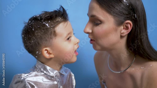 mom in silver dress kisses son in Studio