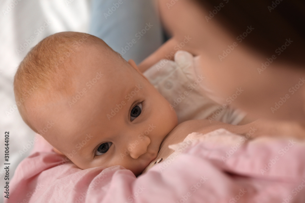 © New Africa - Young woman breast feeding her little baby, closeup