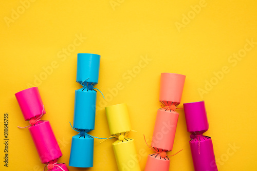 Bright colourful Christmas crackers on a yellow background. festive layflat