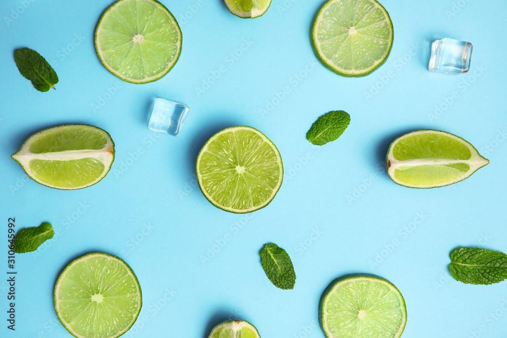 Flat lay composition with fresh juicy limes, mint and ice cubes on light blue background Flat lay composition with fresh juicy limes, mint and ice cubes on light blue background