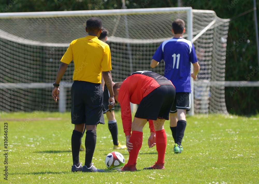 L'arbitre et les joueurs de football avant un coup franc L'arbitre et les joueurs de football avant un coup franc