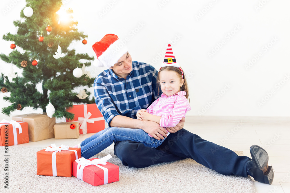 holidays, christmas, family and happiness concept - father and daughter with gift box holidays, christmas, family and happiness concept - father and daughter with gift box