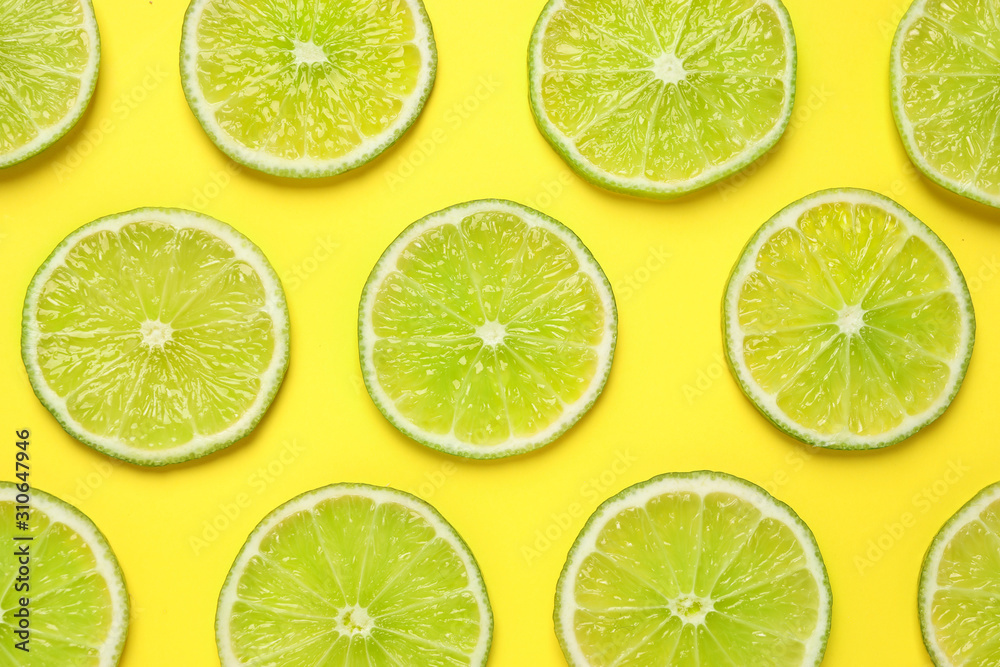 Fresh juicy lime slices on yellow background, flat lay