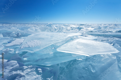 Frozen Lake Baikal. Endless fields of ice hummocks with transparent blue ice floes. Cold winter landscape. Natural background