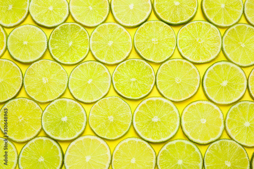 Juicy fresh lime slices on yellow background, flat lay Juicy fresh lime slices on yellow background, flat lay