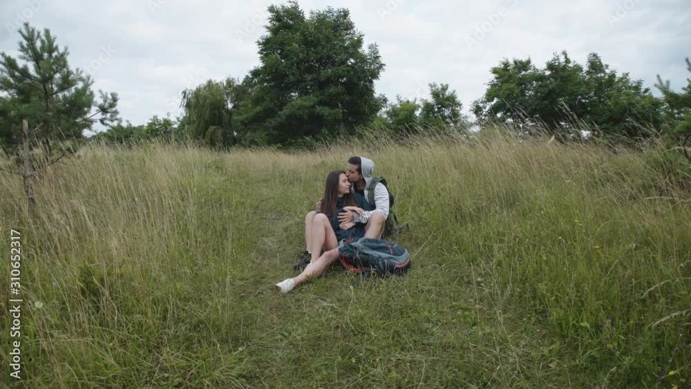 Romantic couple in love relaxing in embraces with kisses on path Romantic couple in love relaxing in embraces with kisses on path