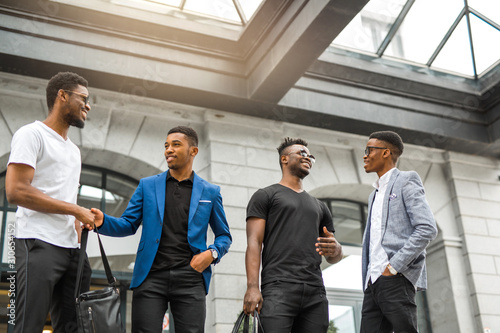 four handsome young african men on the background of the building