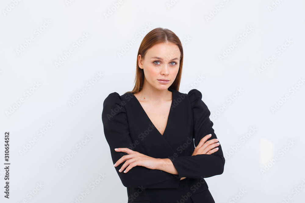 young business woman crossed her arms against a light background. elegance girl on white background young business woman crossed her arms against a light background. elegance girl on white background