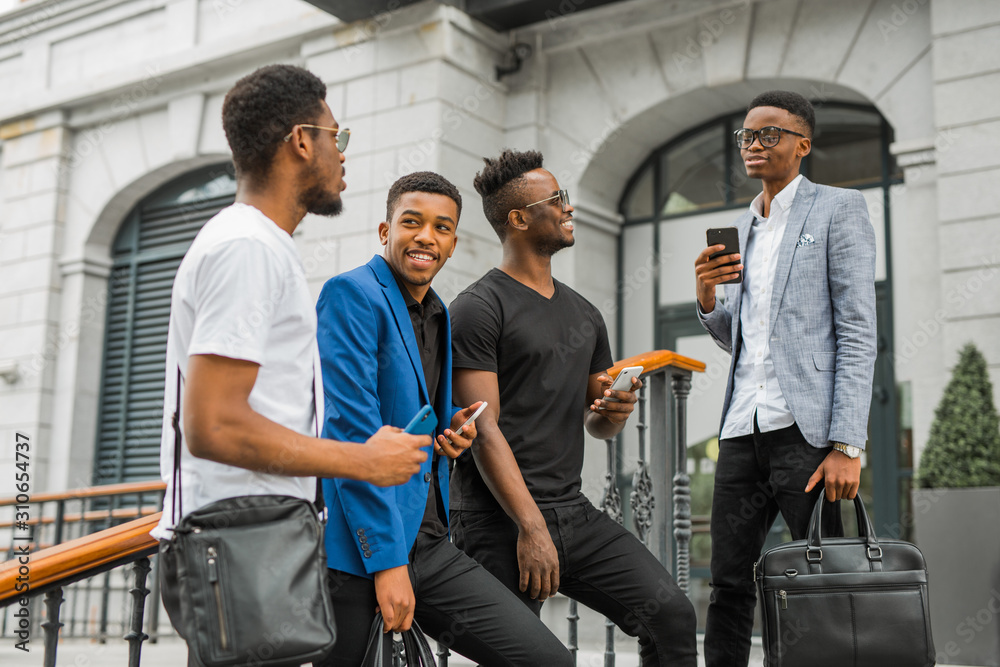 four african men with phones in their hands near the building