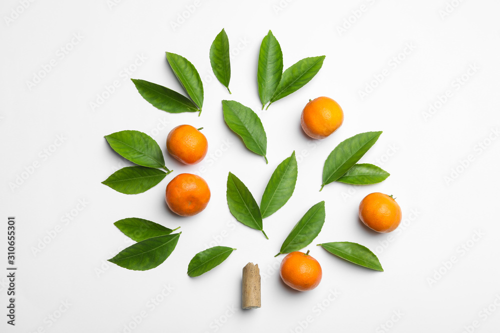 Composition with fresh green citrus leaves and tangerines on white background, top view